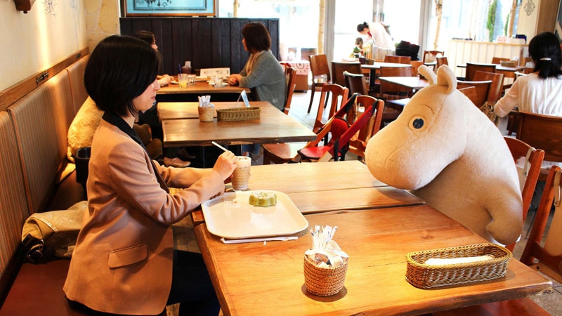 Japanese woman dining in front of a stuffed animal