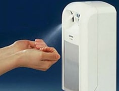 person using a white hand sanitiser dispenser