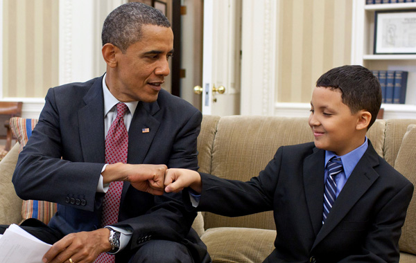 President Obama bumps his hands to a young boy