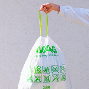 person holding white and green plastic bag