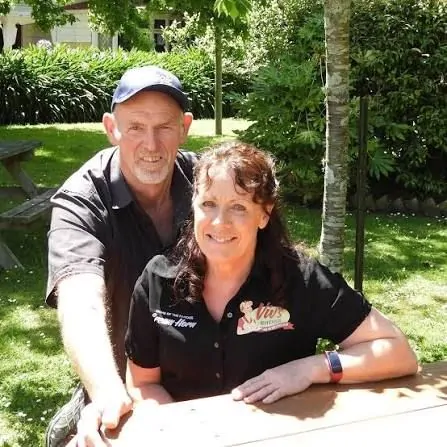 Viv and Kevan of Viv’s Kitchen smiling at an outdoor table in the café garden
